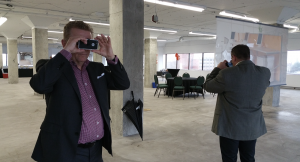 two realtors hold up VR for business viewers in an empty warehouse space